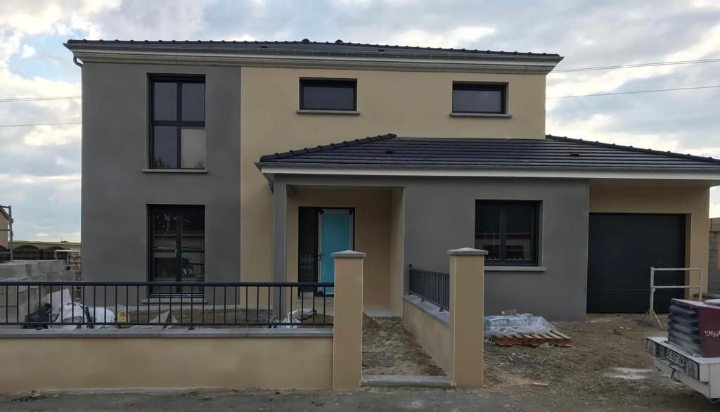 Une maison en construction avec une voiture garée devant